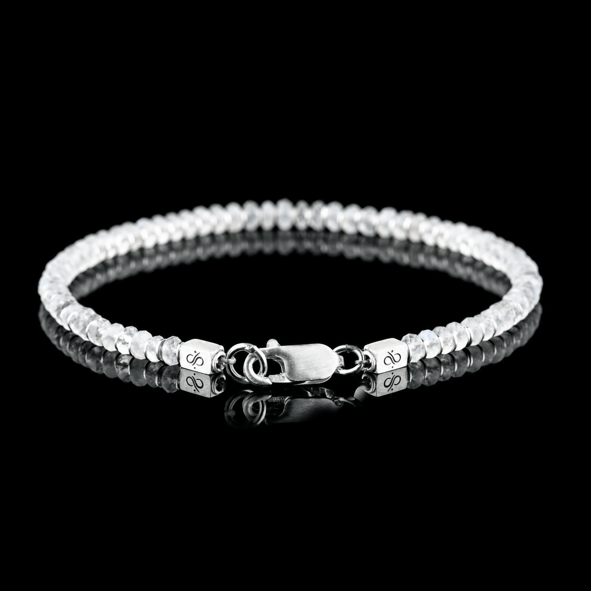 Back view of Moonstone Bracelet X (4mm), showing the clasp and branded end pieces on a black reflective surface.