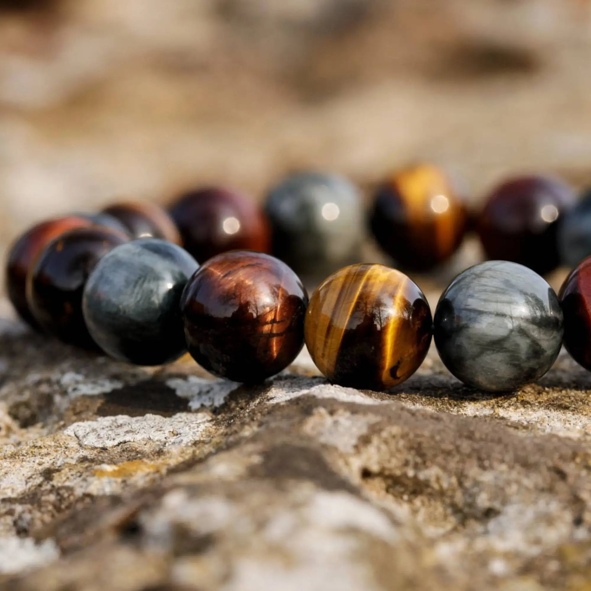 Tiger eye bracelet for men on natural stone surface. Brown, Red, and Grey Eagle Eye beads. Aurum Brothers.