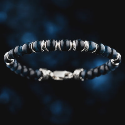 Detail video of Blue Tiger Eye Bracelet IV (6.5mm), showing blue stone banding and paired sculpted silver spacers.