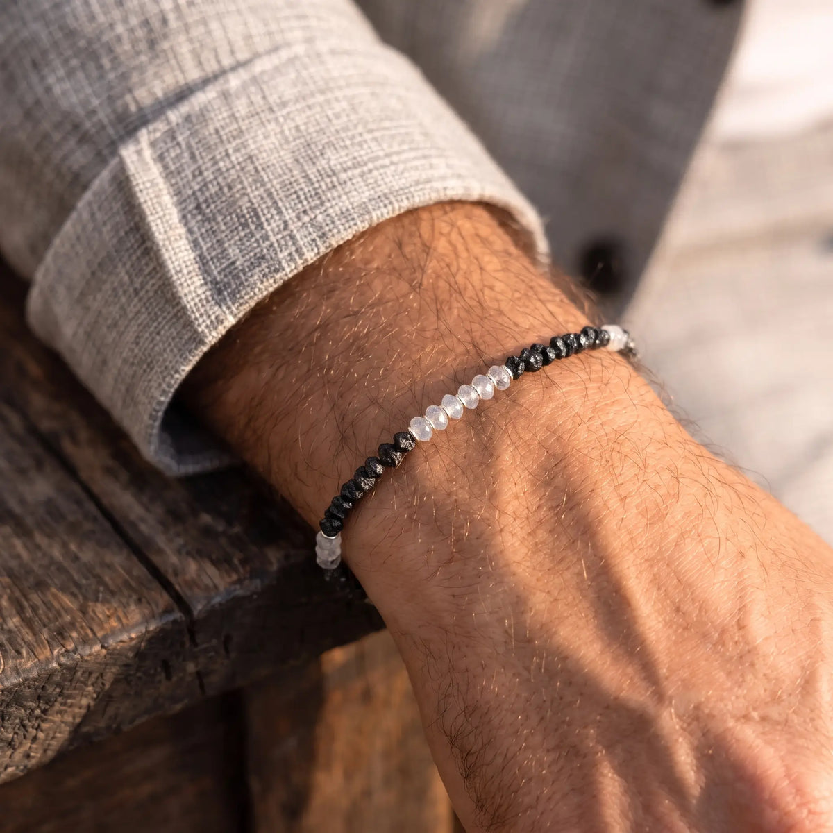 Raw Black Diamond - Moonstone Bracelet I (3-4mm), with pale faceted moonstone and rough black diamond sections, worn beside a grey sleeve.