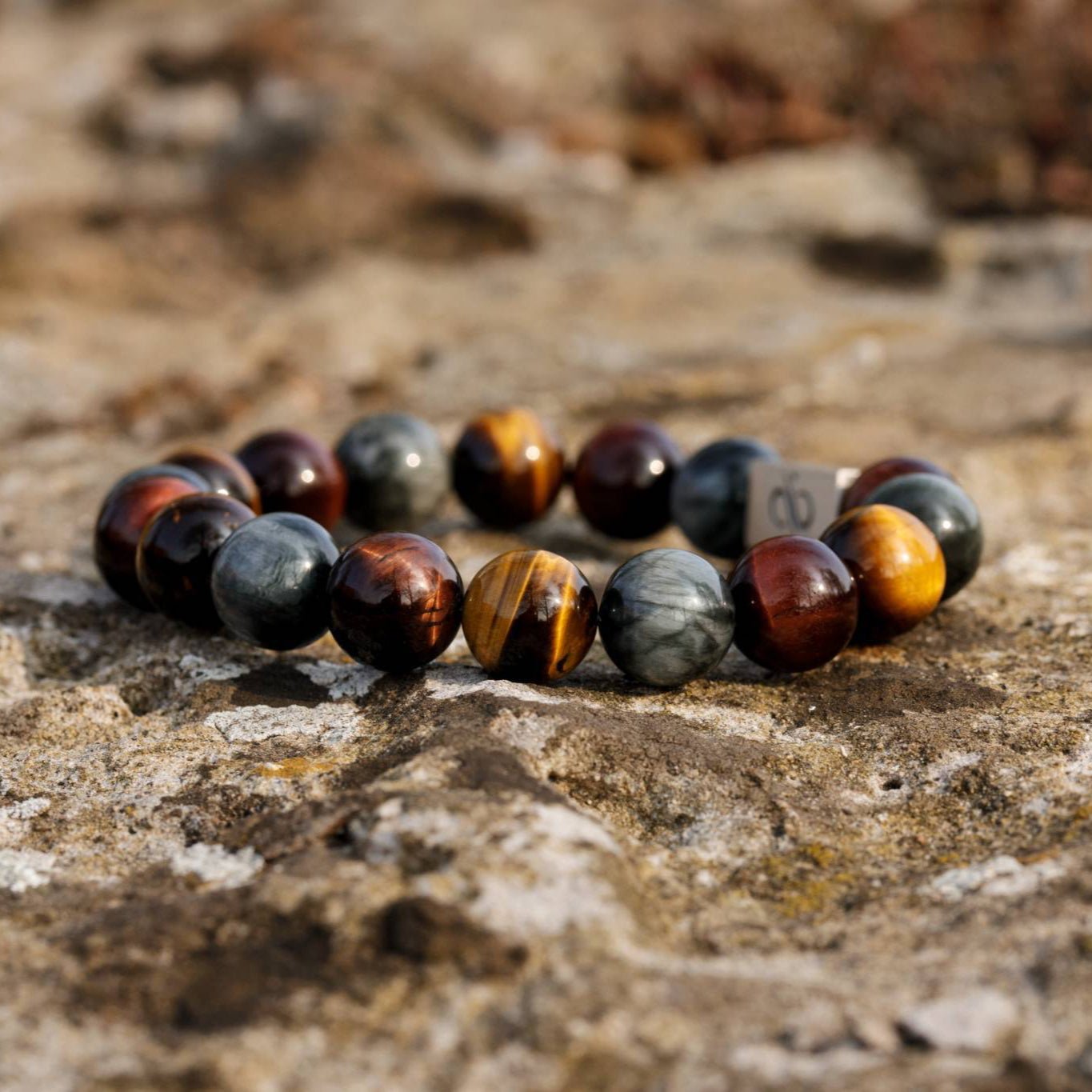 Tiger eye bracelet for men on natural stone surface, lifestyle view. 12mm Classic design. Aurum Brothers.